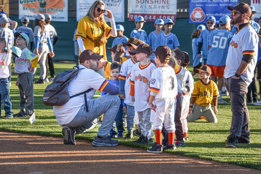 T-Ball Coach Raj Lapsiwala chats with the 4- to 7-year-old players on his team as they wait for the ceremony to begin.