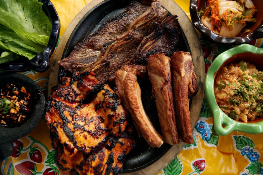 Korean kalbi short ribs, charcoal pork ribs, spicy chicken thighs and a variety of banchan and garnishes from Guerrilla Tacos.
