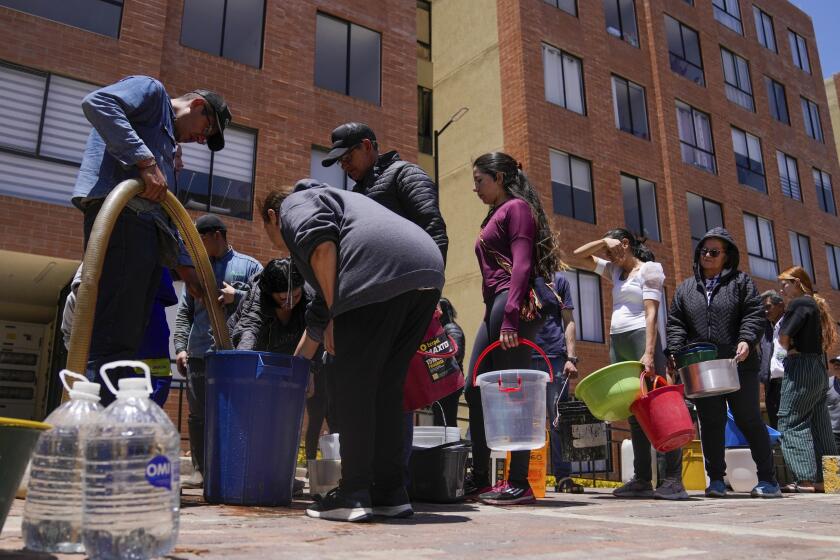 Los residentes hacen fila para recoger agua de un camión durante el racionamiento de agua en La Calera, en las afueras de Bogotá, Colombia, el martes 16 de abril de 2024. (AP Photo/Fernando Vergara)
