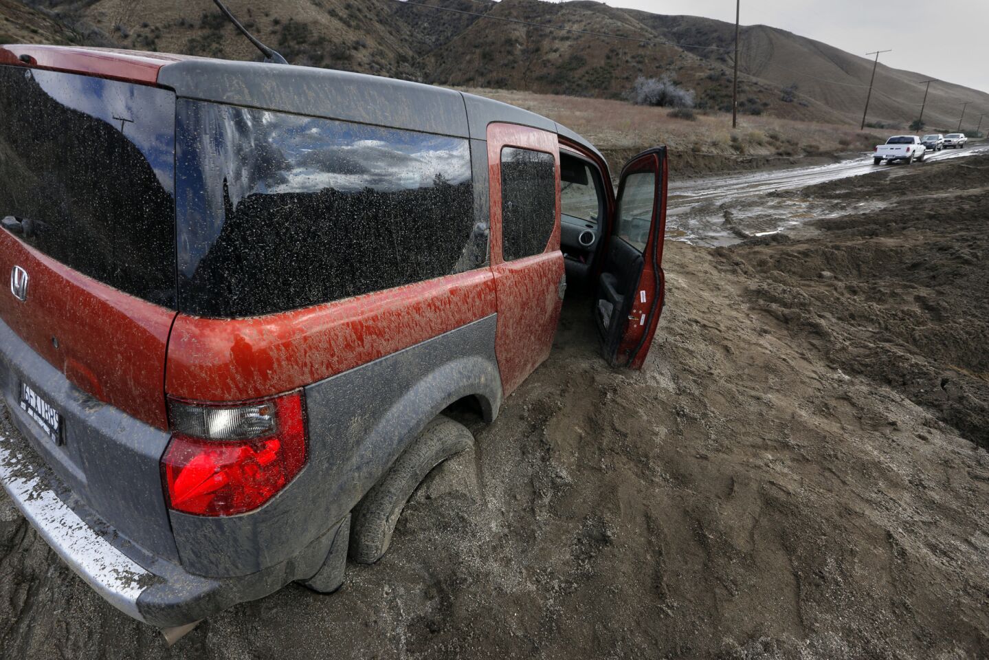 Several cars on Elizabeth Lake Road are inundated with mud after the deluge .