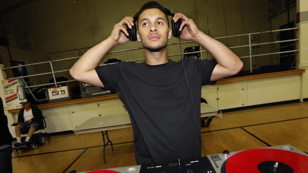 DJ Lean Rock provides the music for a public session at Salazar Park Community Center the night before the competition.
