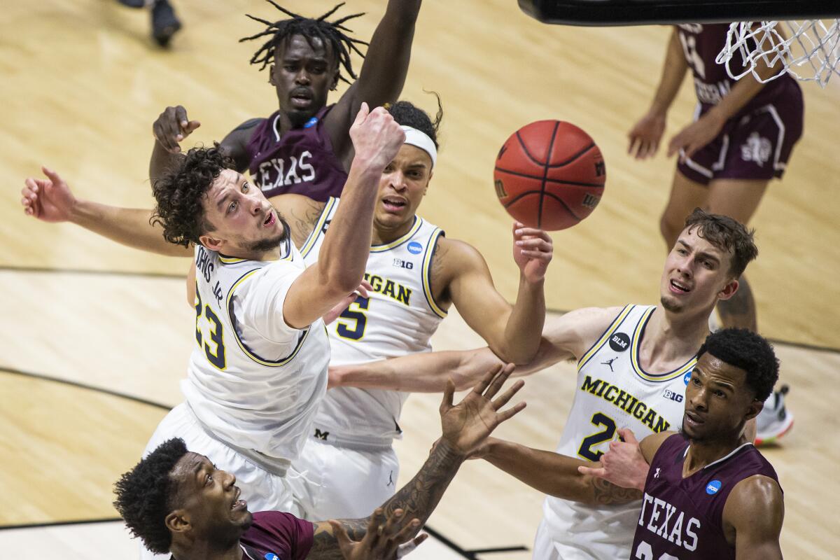Michigan and Texas Southern players battle for a rebound.