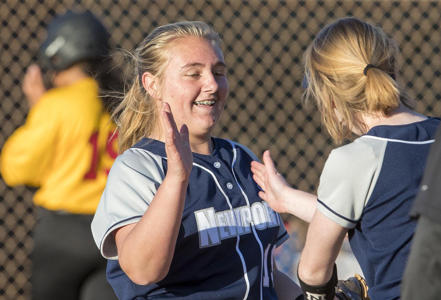 Newport Harbor's Clare Austin gets a high five from teammate Lily Larkins after closing out the game against Estancia on Wednesday, February 28.