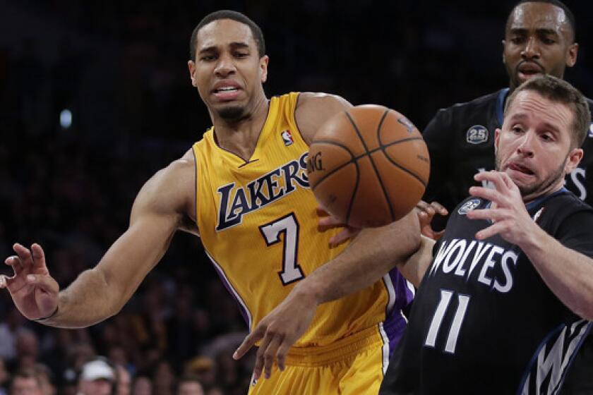 Lakers forward Xavier Henry (7) battles Minnesota Timberwolves guard J.J. Barea for a loose ball during a game in December.