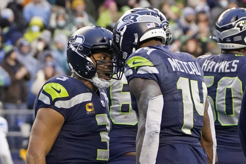 Seattle Seahawks quarterback Russell Wilson, left, reacts with wide receiver DK Metcalf (14) after he passed Metcalf for a touchdown against the Detroit Lions during the second half of an NFL football game, Sunday, Jan. 2, 2022, in Seattle. (AP Photo/Elaine Thompson)