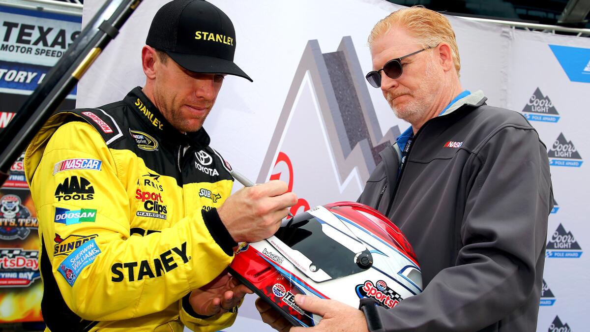 Carl Edwards signs a ceremonial winner's helmet after winning the pole position Thursday for the Sprint Cup race at Texas Motor Speedway.