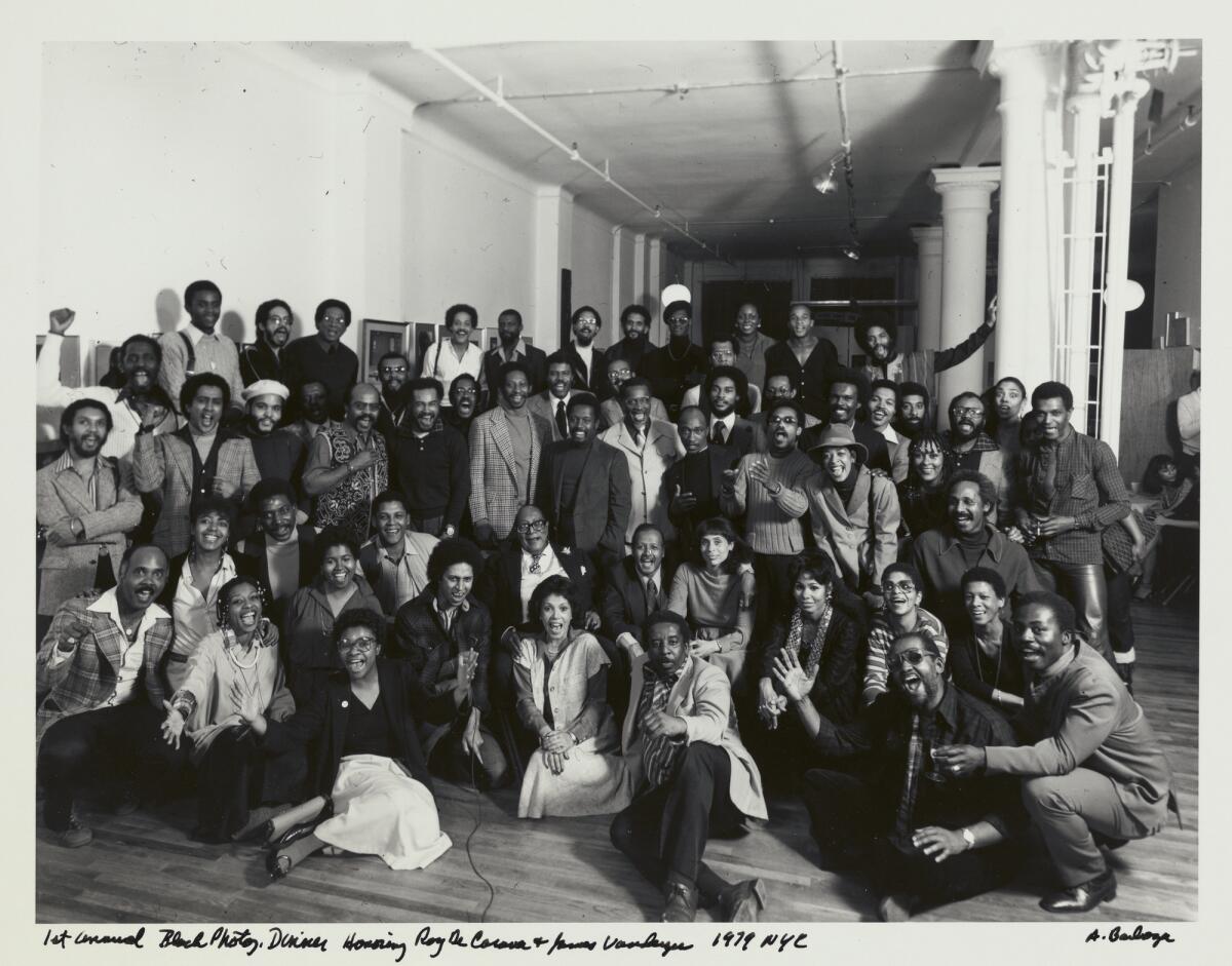 A large group of people pose in black-and-white photograph.
