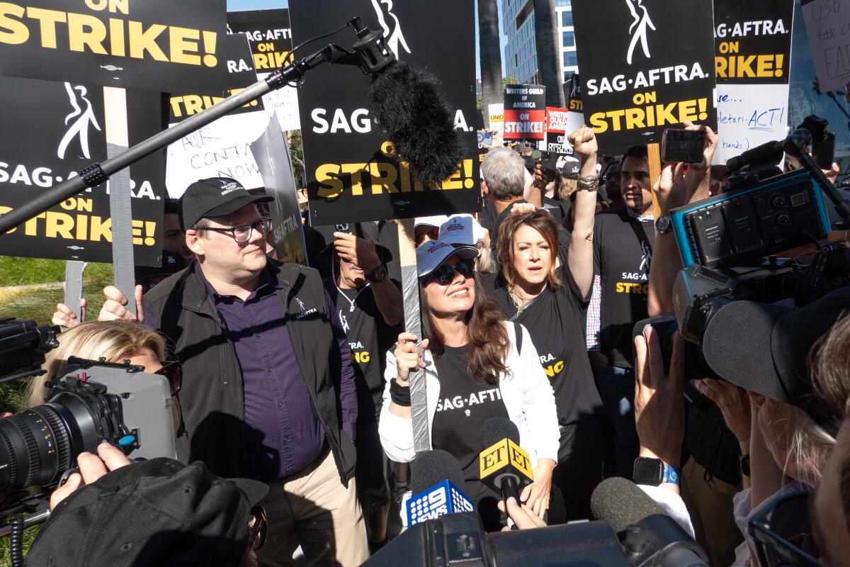 A large crowd of people holding picket signs that say "SAG-AFTRA on strike!"