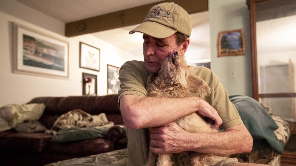 Paul Hoffman of Costa Mesa holds Buddy, a 14-year-old blind dog whom Hoffman took in after the death of his owner.