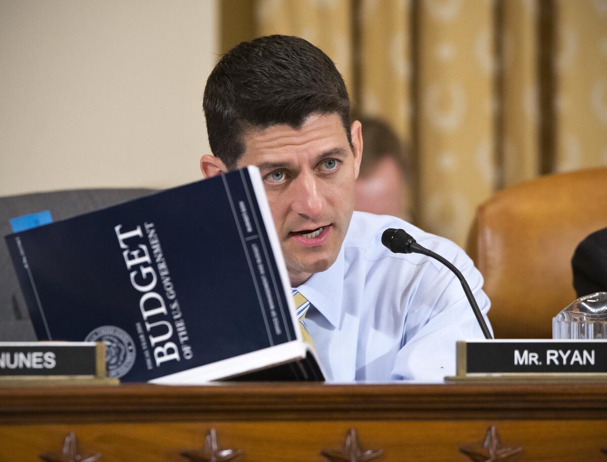 House Budget Committee Chairman Rep. Paul Ryan (R-Wis.) holds a copy of President Obama's fiscal 2014 budget proposal book during a House Ways and Means Committee hearing on Capitol Hill in Washington.
