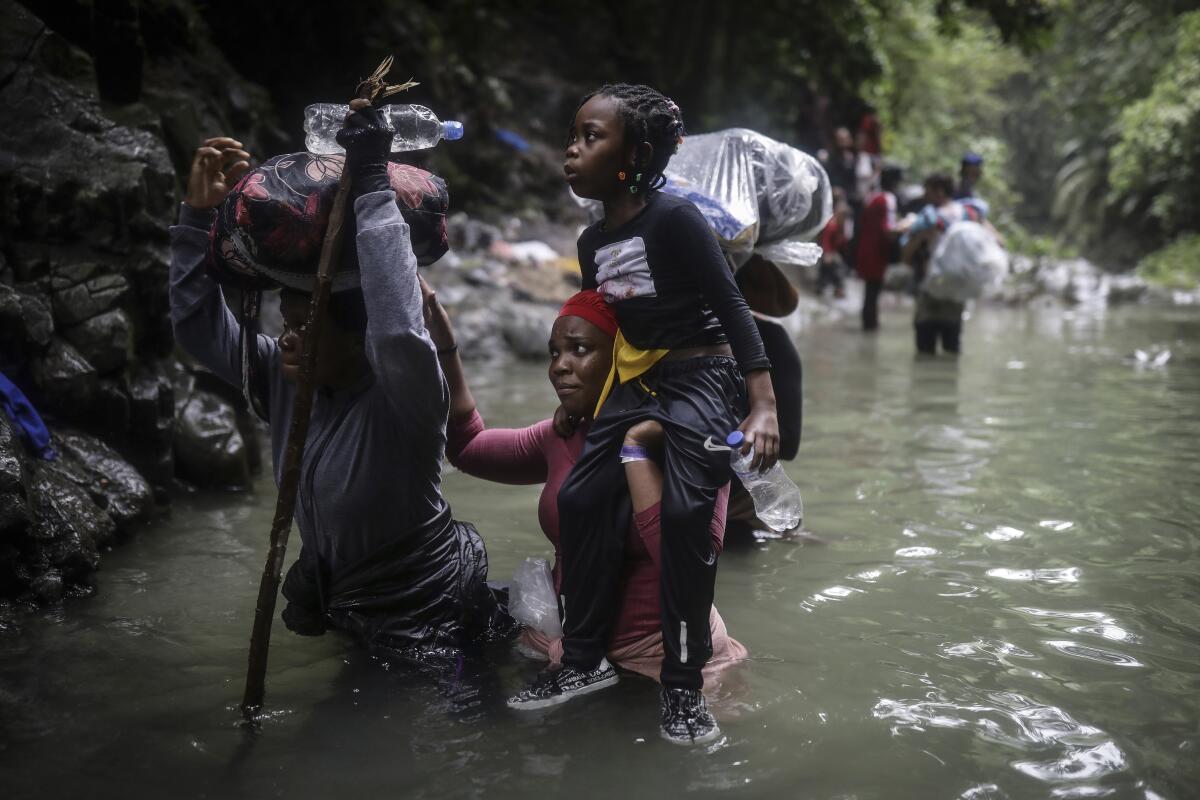 Migrantes haitianos caminan por el agua mientras cruzan el Tapón del Darién, de Colombia a Panamá 