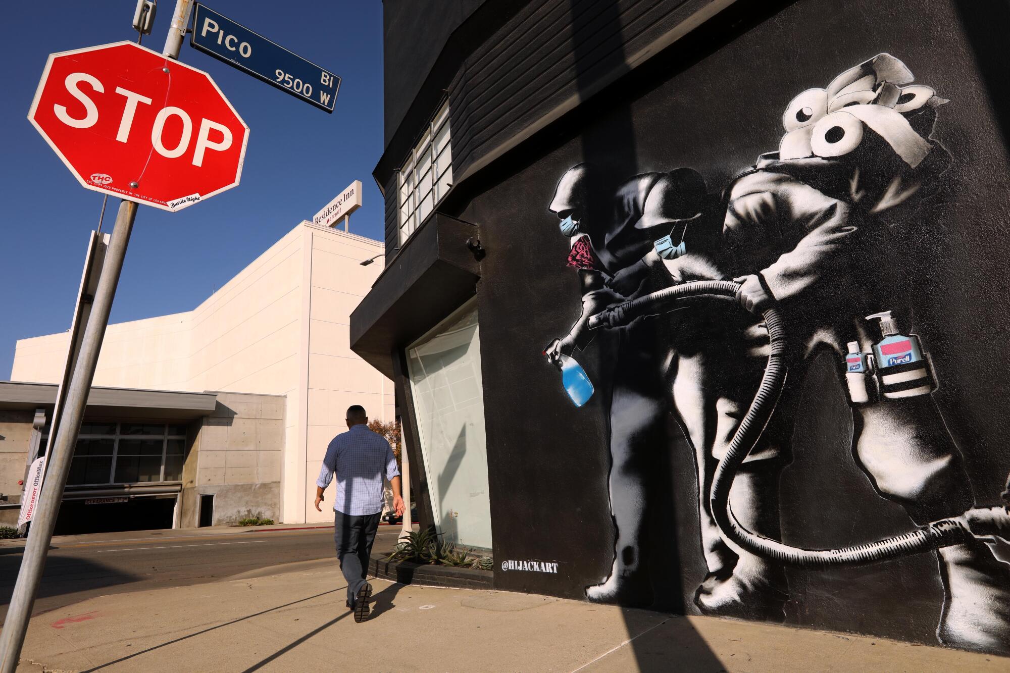  A man walks past a mural. 