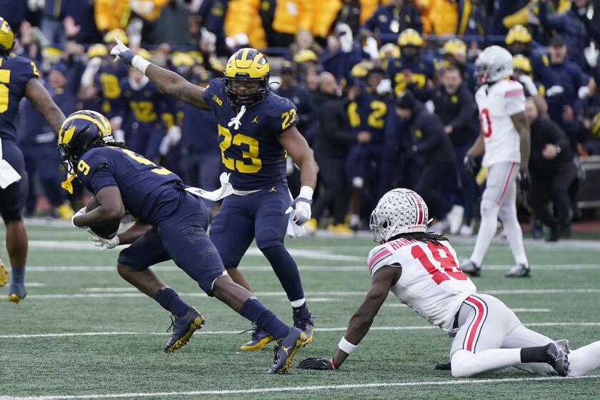 Michigan defensive back Rod Moore (9) intercepts a pass intended for Ohio State wide receiver Marvin Harrison Jr. (18) during the second half of an NCAA college football game, Saturday, Nov. 25, 2023, in Ann Arbor, Mich. (AP Photo/Carlos Osorio)
