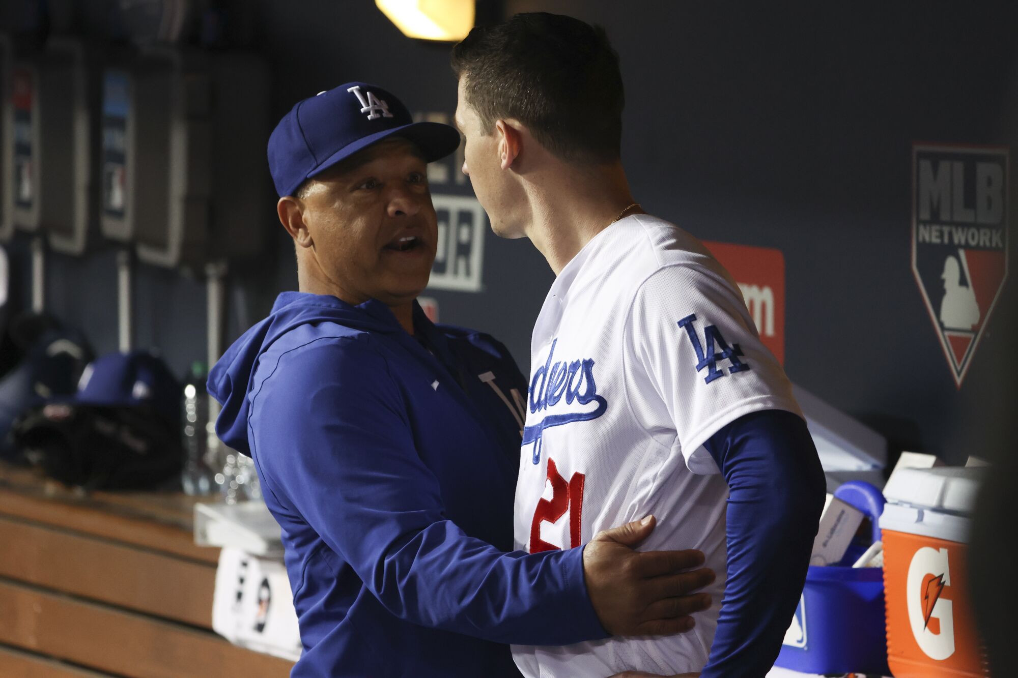 Dodgers manager Dave Roberts speaks with Walker Buehler in the dugout.