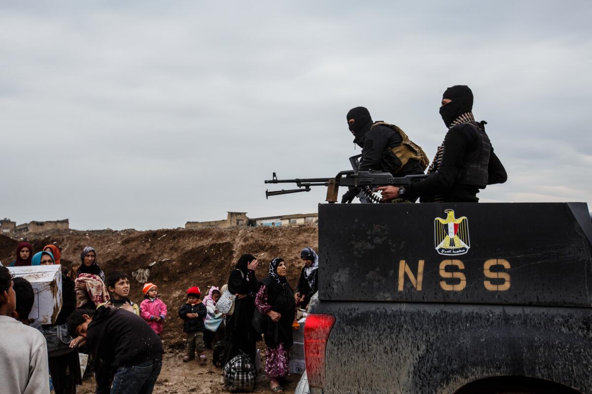 National Security Service members stand guard March 23 outside the camp at Hammam Alil.