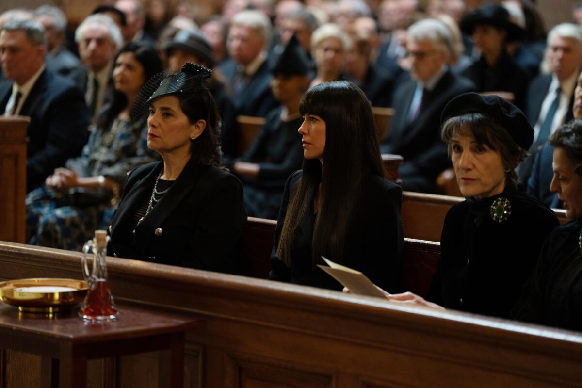 Four women in black funeral attire sit side-by-side in a church pew on an episode of "Succession."