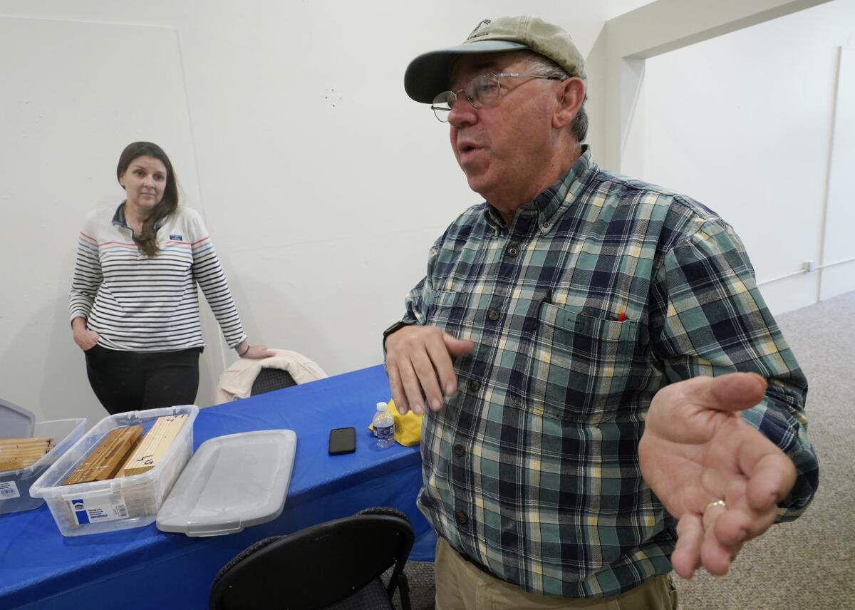 Co owner of Building Resilient Solutions, Kerry Shackelford, right, gestures as he describes the process for testing wood along with Paige Pollard, left, at their lab Tuesday, Oct. 4, 2022, in Suffolk, Va. Whenever historic homes get flooded, building contractors often feel compelled by government regulations to rip out the water-logged wood flooring, tear down the old plaster walls and install new, flood-resistant materials. But Virginia restorers Paige Pollard and Kerry Shackelford say they can prove that historic building materials can often withstand repeated flooding. (AP Photo/Steve Helber)