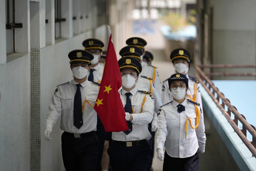 Çin bayrağı taşıyan üniformalı öğrenciler