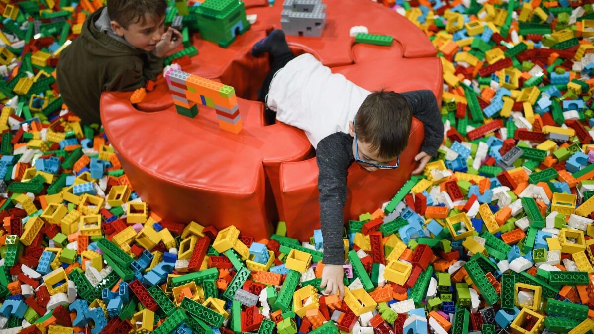 Lego will cut jobs and simplify the company in response to a sales decline. Above, children play at a recent event in Scotland.