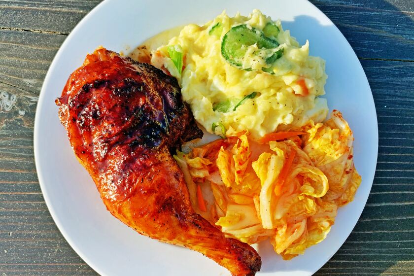 Gochujang-glazed chicken on the grill." and the other is "Gochujang-glazed grilled chicken with potato salad and kimchi.
