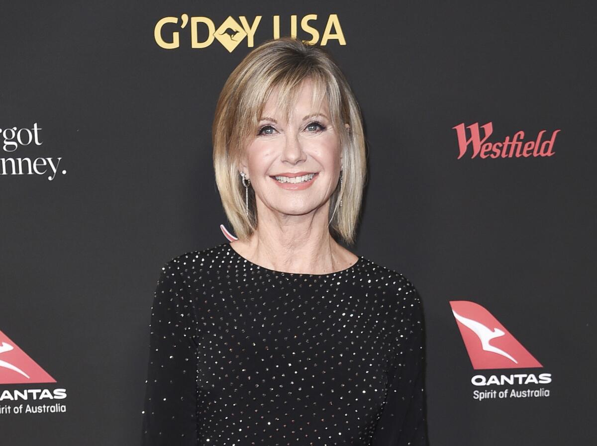  Olivia Newton-John smiling and dressed for a gala in 2018 