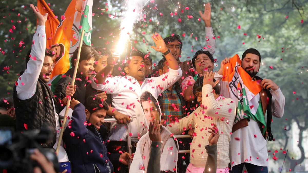 Congress party workers celebrate the party's lead in vote counting and potential victory in Assembly elections, at party headquarters in New Delhi on Dec. 11.