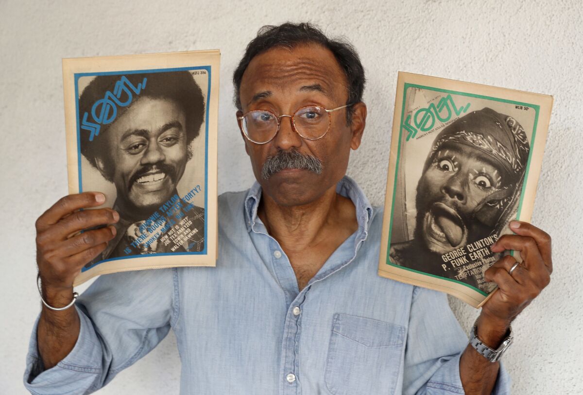 Bruce Talamon holds up photographs he made of musicians Johnnie Taylor, left, and George Clinton, that appeared on the cover of Soul Magazine back in 1977