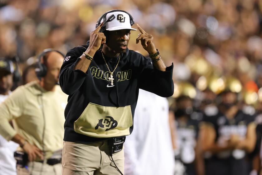 Colorado coach Deion Sanders signals to his players during a game.