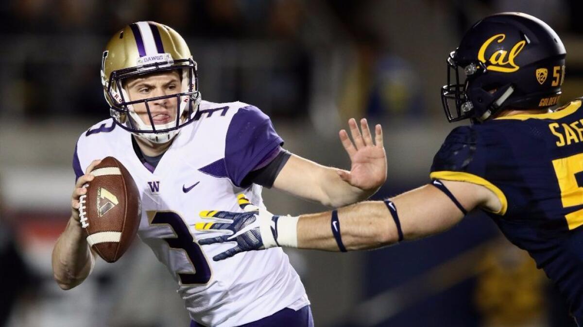 Huskies quarterback Jake Browning is pressured by a California defender during a game on Nov. 5.