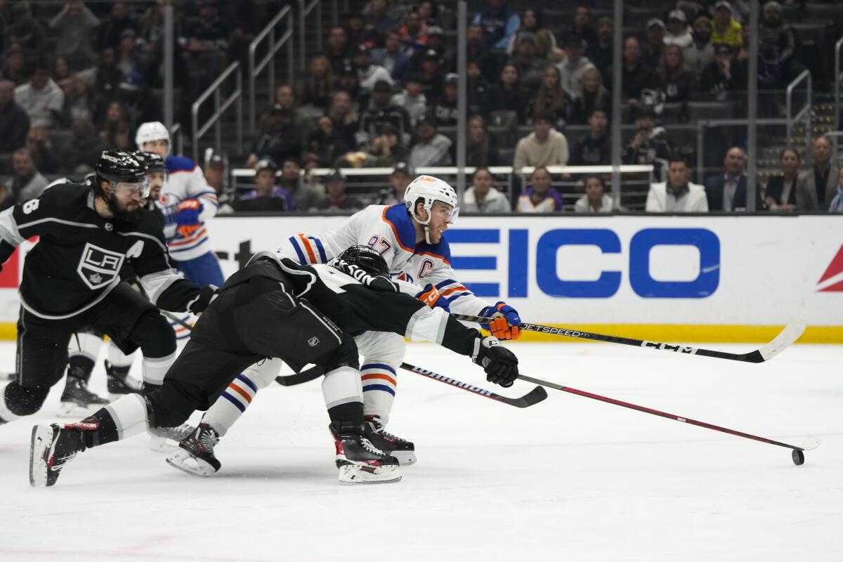 Edmonton's Connor McDavid shoots while defended by Kings' Mikey Anderson.