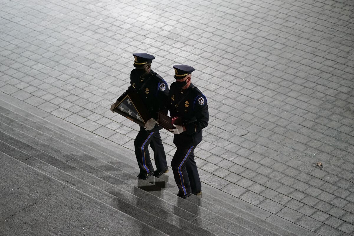 An honor guard carries an urn up U.S. Capitol steps. 
