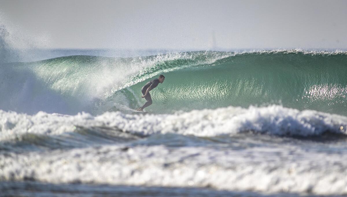 A surfer gets a tube ride in Newport Beach in early July, where temperatures topped out at 103 degrees on July 6.