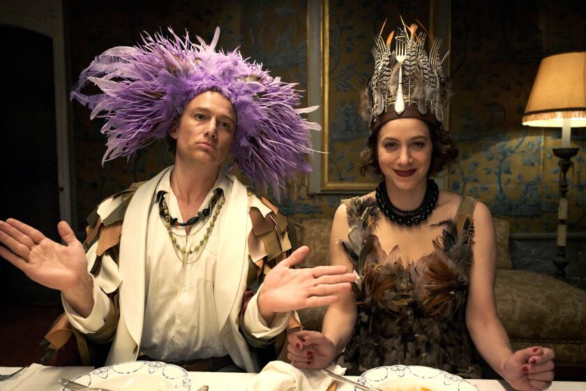 Max Ernst in purple feather headdress and Peggy Guggenheim in fork and feather crown.