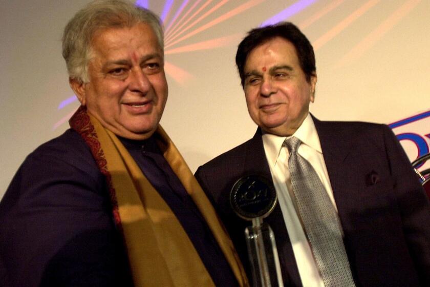 FILE- In this June 2, 2005 file photo, legendary Bollywood actor Dilip Kumar, right, looks at veteran actor Shashi Kapoor, left, at the inauguration of a new cinema in Mumbai, India. Kapoor was felicitated at the event. Kapoor, a prolific Bollywood actor and producer from the 1970s and '80s, died Monday, Dec. 4, 2017 after a long illness. He was 79. (AP Photo/Aijaz Rahi, File)