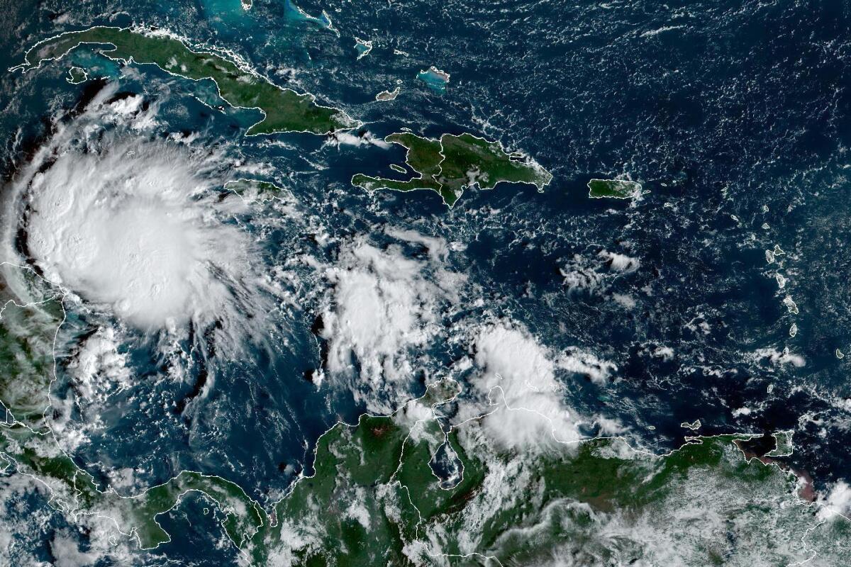 This satellite image taken at 8:40am ET and provided by NOAA shows Tropical Storm Lisa under Cuba in the Caribbean Sea, Tuesday, Nov. 1, 2022. Lisa is forecast to make landfall in Central America later in the week as a likely hurricane. (NOAA via AP)
