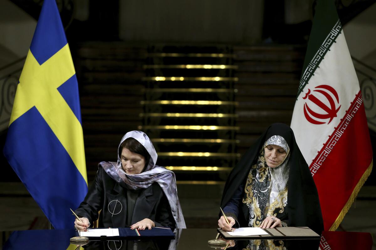 Swedish Trade Minister Ann Linde, left, and Iran's Vice President for Women and Family Affairs Shahindokht Molaverdi sign documents at the Saadabad Palace in Tehran.