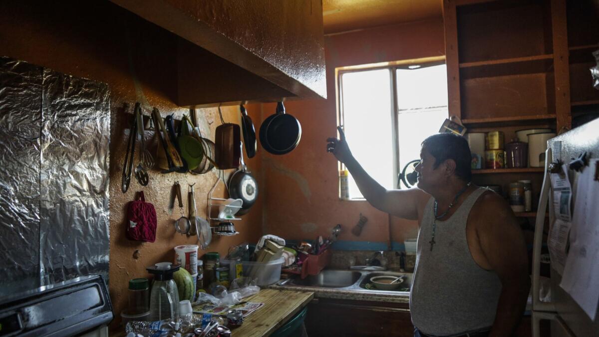 Jose Nunez, 62, points at cracks in the walls at the apartment where he is facing eviction. The county will consider a motion Tuesday to put in place a temporary law limiting annual rent increases and requiring landlords to give a legitimate reason when evicting tenants.