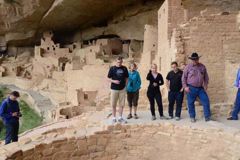 Tourists assess Cliff Palace in Mesa Verde National Park, Colo.
