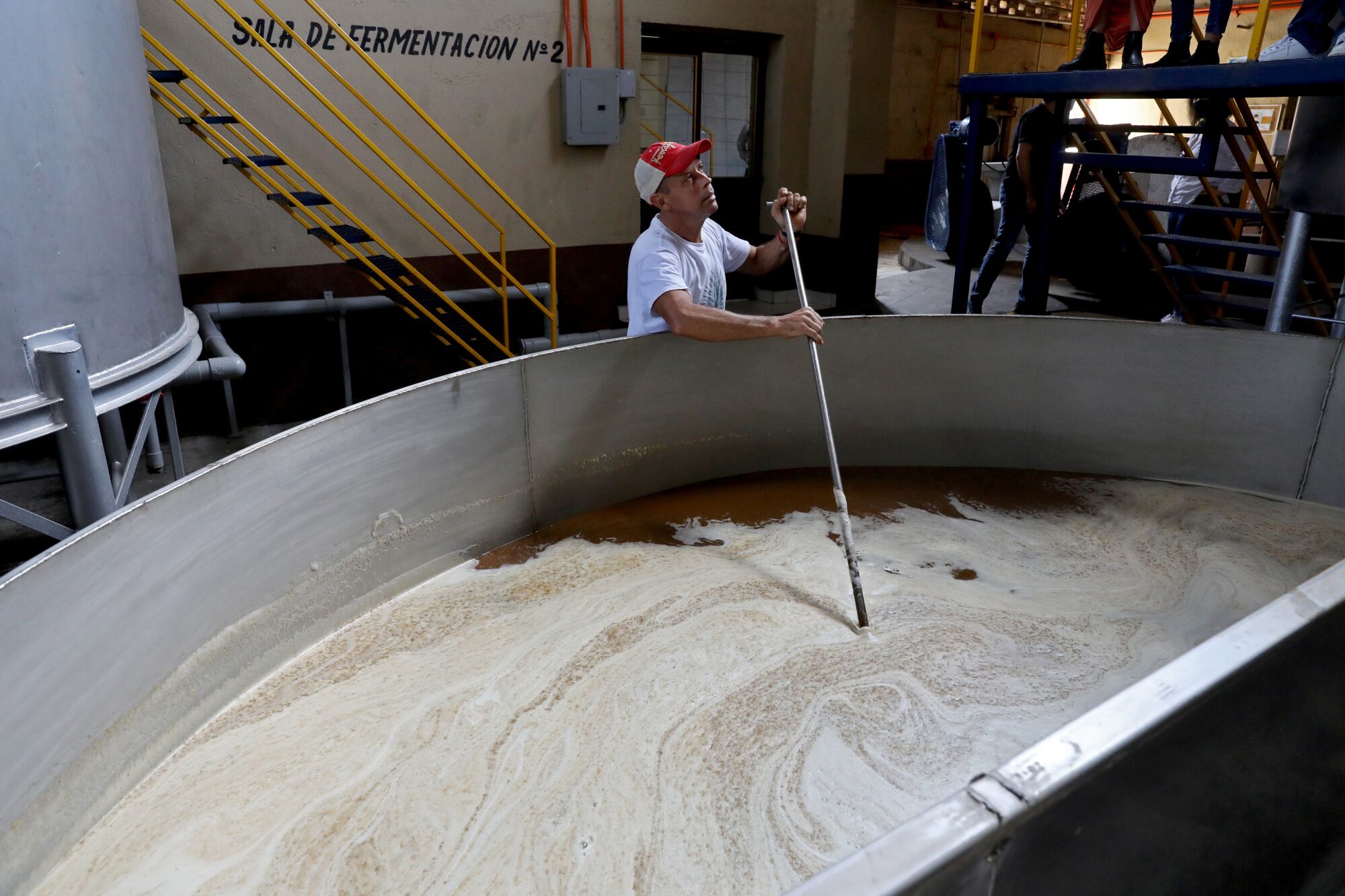 A worker agitates sweet agave juice to later be fermented with yeast at Cascahuin Tequila distillery.