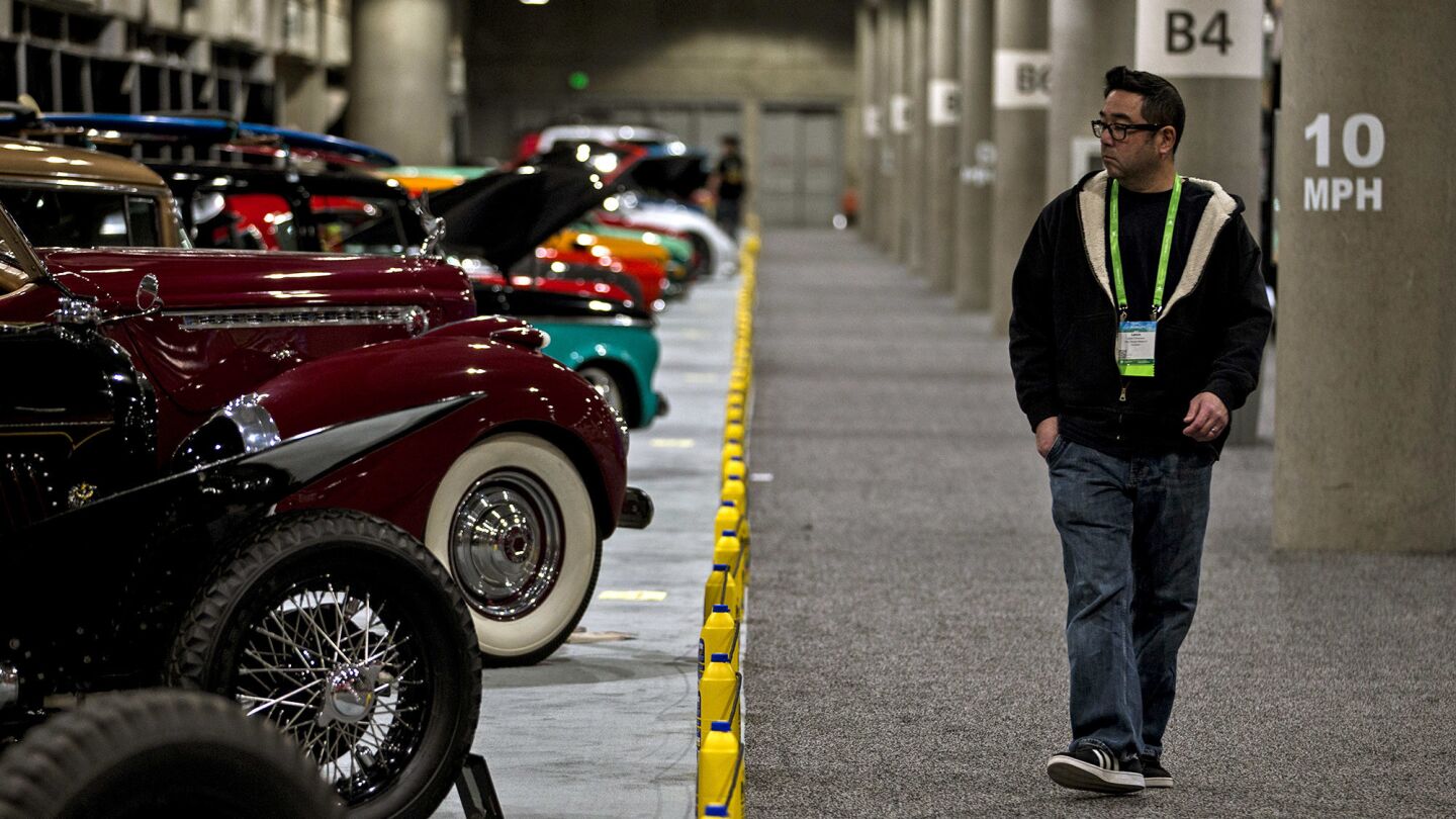 Lance Chikasawa walks past the Prestone custom car display in the Garage.