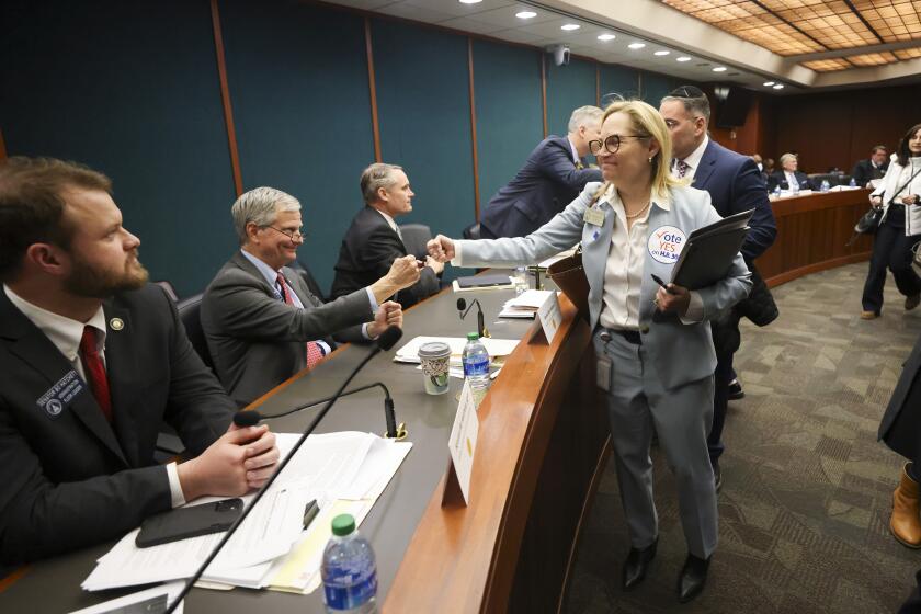 FILE - Rep. Esther Panitch, D-Sandy Springs, right, fist bumps Sen. Ben Watson, R-Savannah, a member of the Senate Judiciary Committee, after House Bill 30, an antisemitism bill, was passed unanimously by the Senate Judiciary Committee in the Coverdell Legislative Office Building, Jan. 22, 2024, in Atlanta. A handful of U.S. states are considering measures that would define antisemitism, but there's debate over whether they would stifle criticism of Israel. (Jason Getz/Atlanta Journal-Constitution via AP, file)