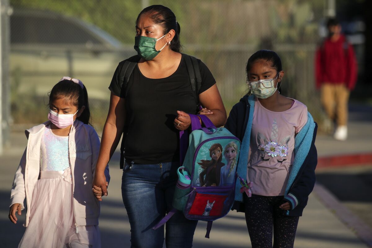 Students and parents arrive to school in Los Angeles wearing face coverings.