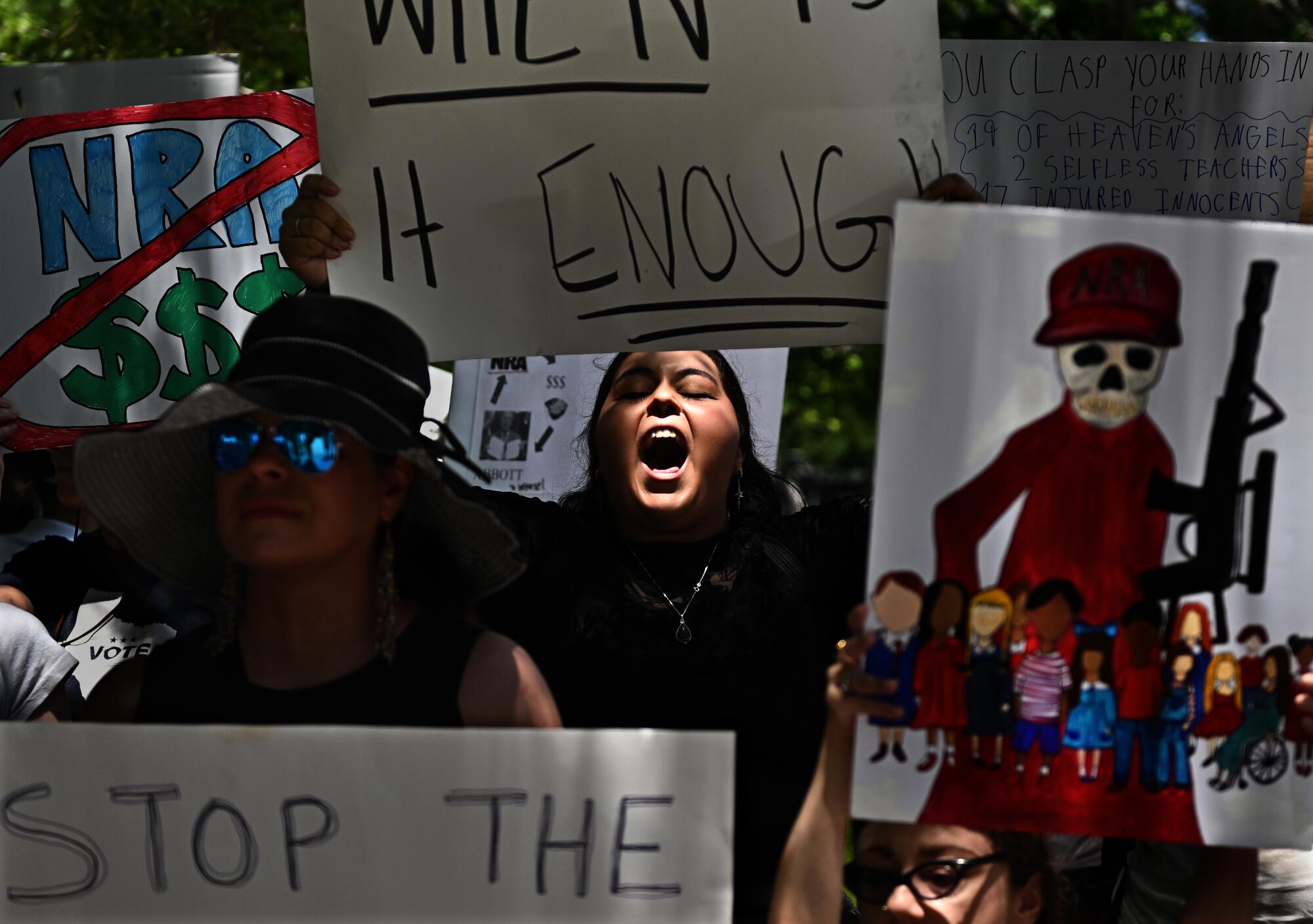 Protestors shout and hold signs