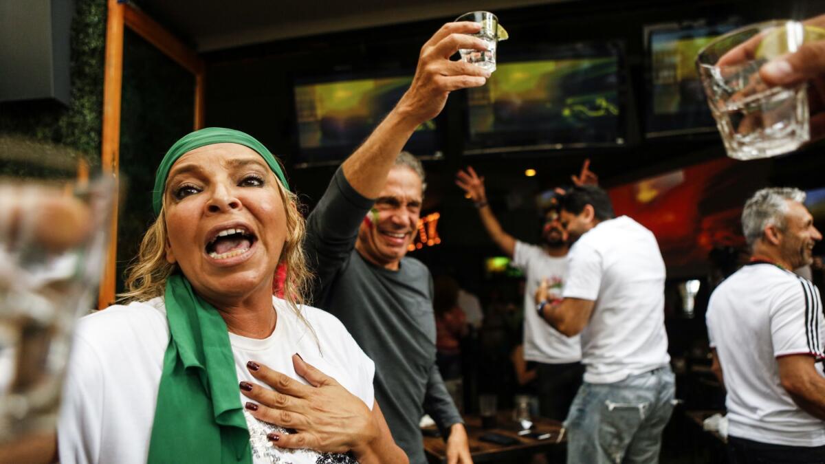 Mandy Molesten, left, cheers with a shot of tequila at The Parlor, a bar on Melrose, after Iran beat Morocco in World Cup soccer.