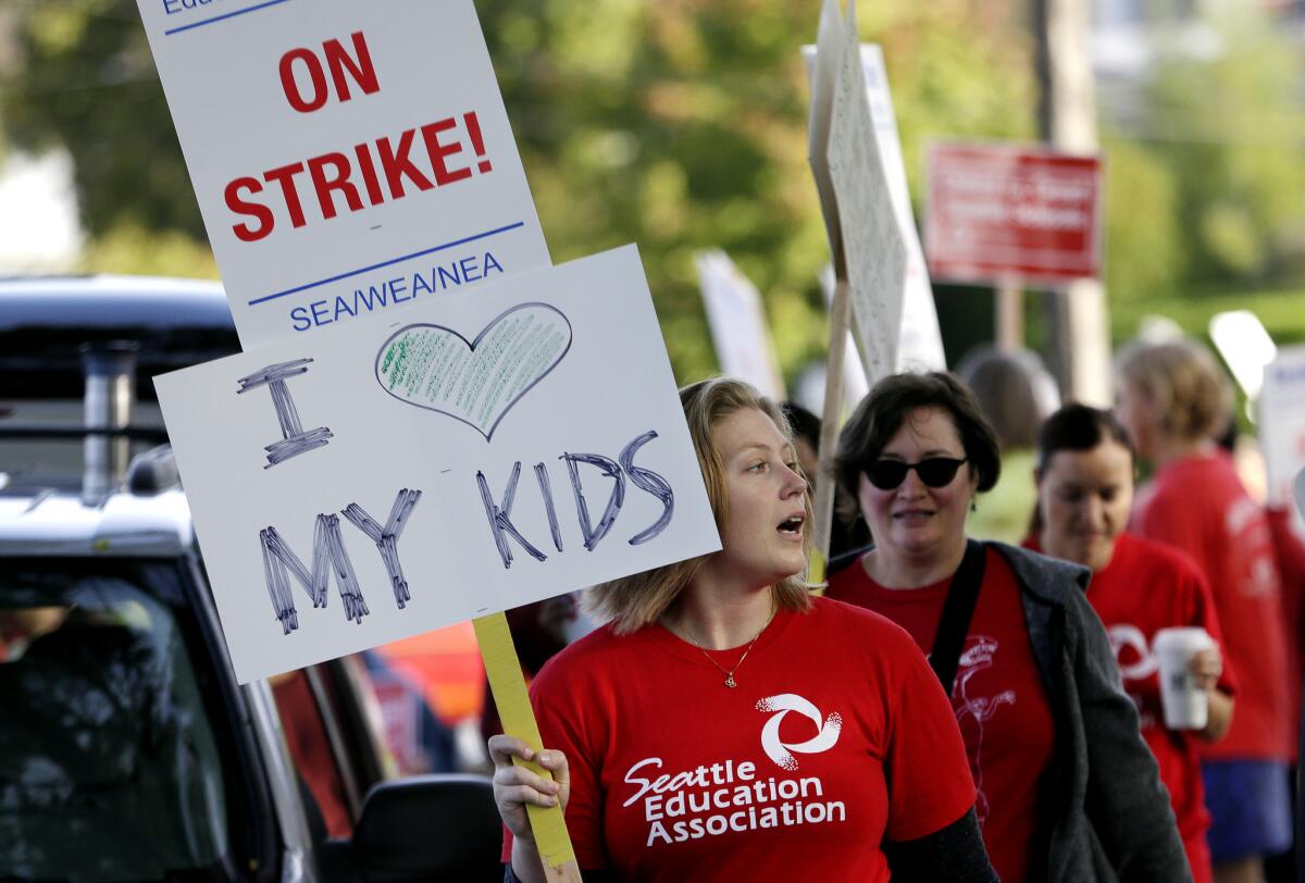 Teachers at West Seattle Elementary School begin walking a picket line Wednesday morning, Sept. 9, in Seattle after last-minute negotiations over wages and other issues failed to avert a strike in Washington state's largest school district.