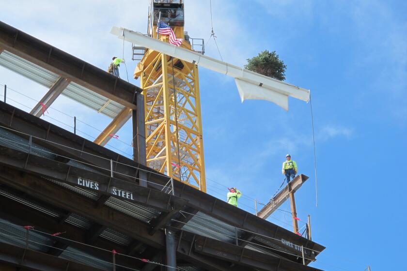 On June 6, iron workers guide the final steel beam into place at the site of the Clinical Sciences Center under construction by Roswell Park Cancer Institute in Buffalo, N.Y. The project is among more than $4.4 billion worth of development announced in the former Rust Belt city since 2012, bolstering hope for an economic recovery.