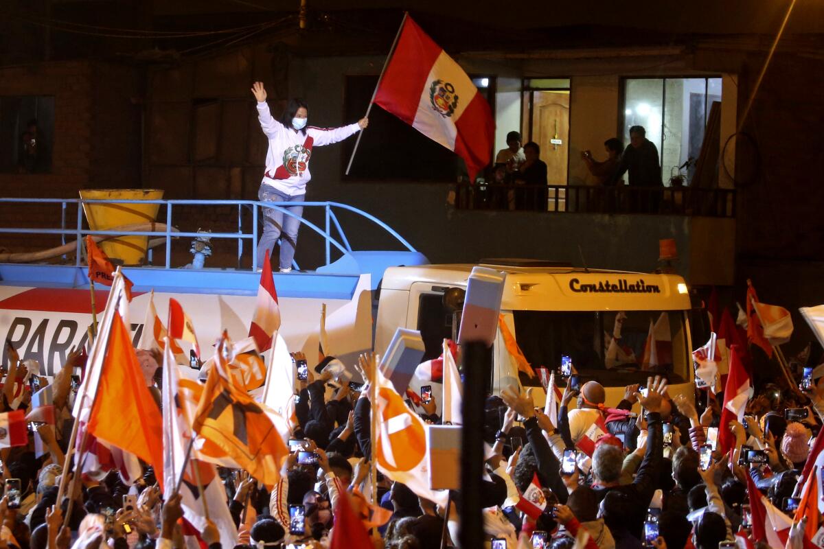 Keiko Fujimori waves from above a large vehicle to supporters below