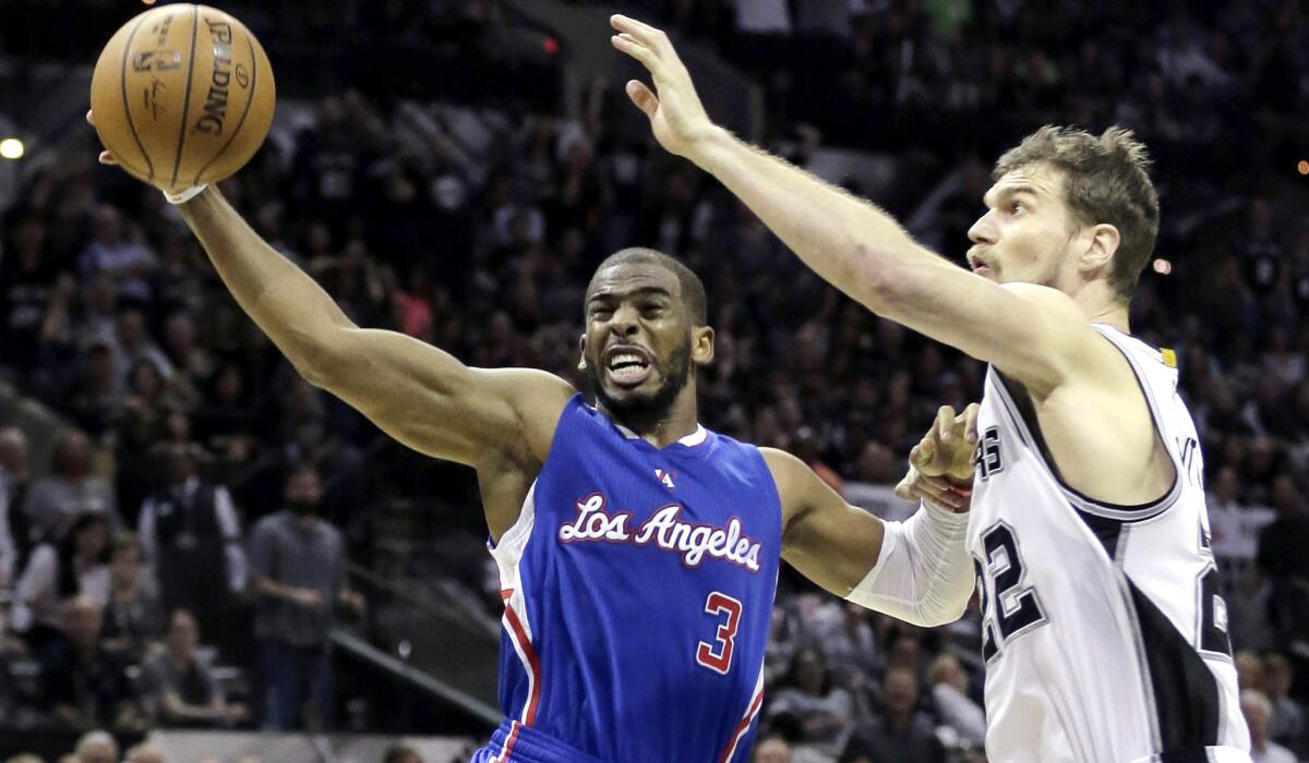 Clippers point guard Chris Paul (3) has his layup challenged by Spurs center Tiago Splitter in the second half of Game 4.