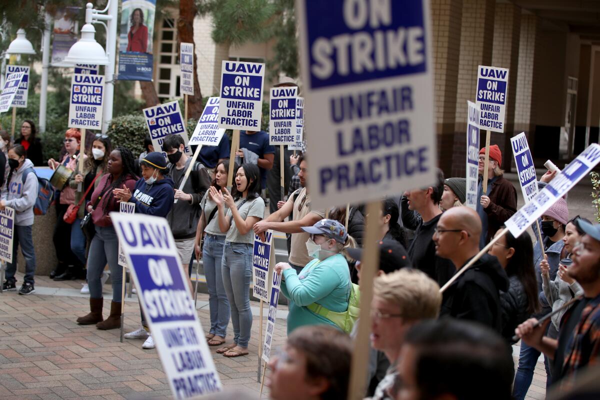 People hold strike signs at a protest