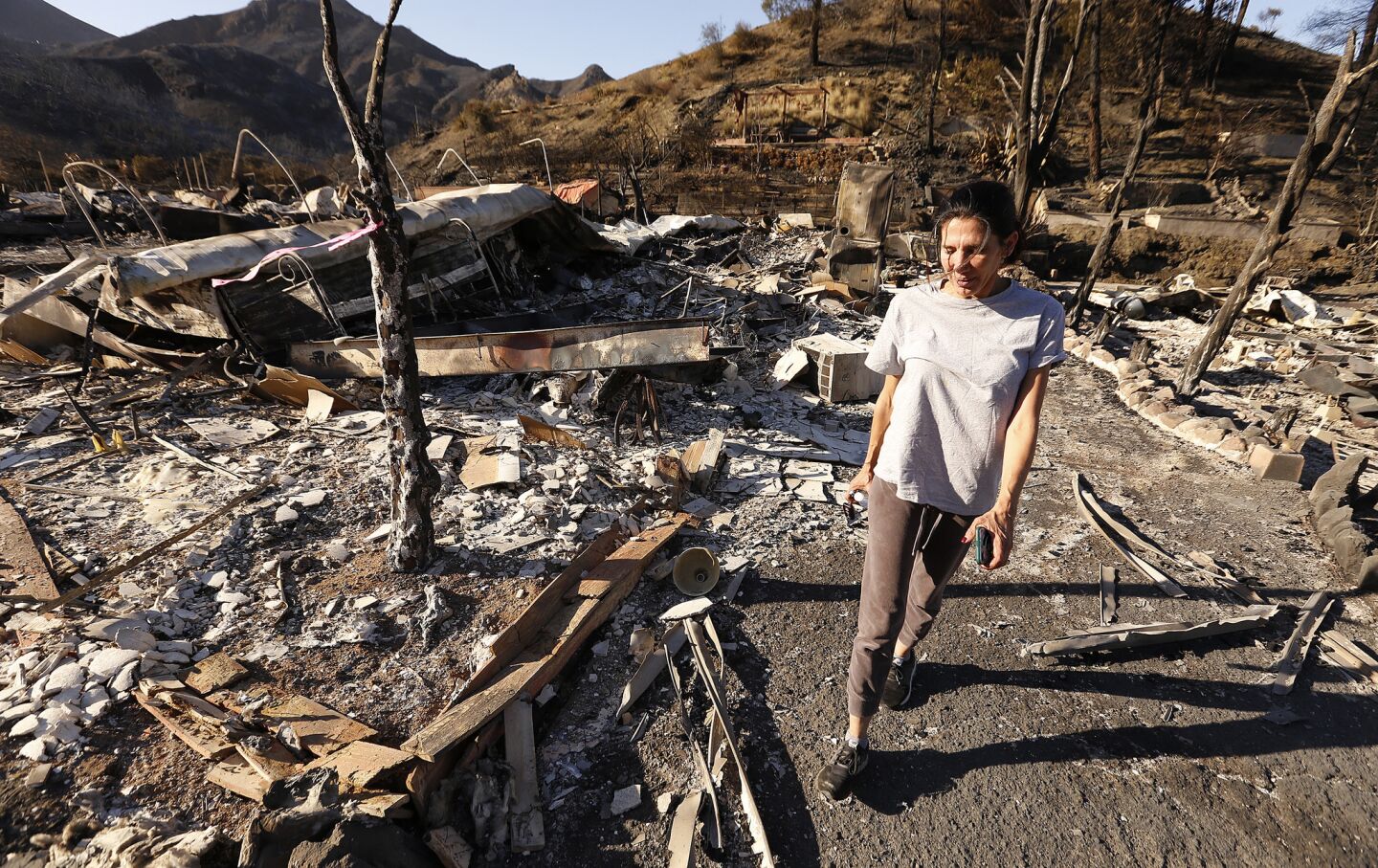 Seminole Springs Mobile Home resident Barbara Sottile walks past homes of friends destroyed in the fire.
